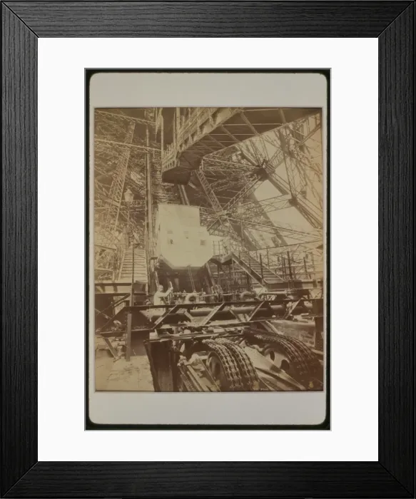 Framed Print : Eiffel Tower machinery with man beside wheel that raises ele Framed Print : Eiffel Tower machinery with man beside wheel that raises ele