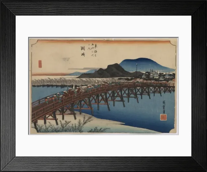 Framed Print : Okazaki. Print shows travelers on a bridge across a river with buildings Framed Print : Okazaki. Print shows travelers on a bridge across a river with buildings