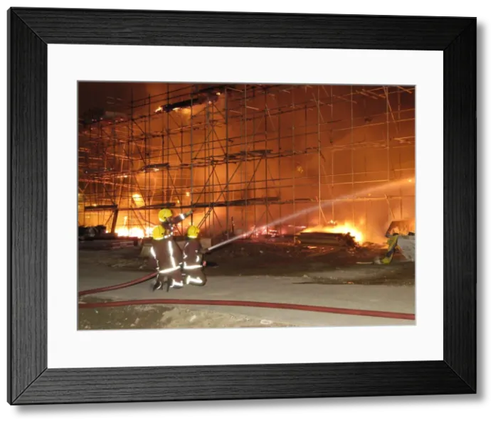 Framed Print : Firefighters working at fire on building site Framed Print : Firefighters working at fire on building site
