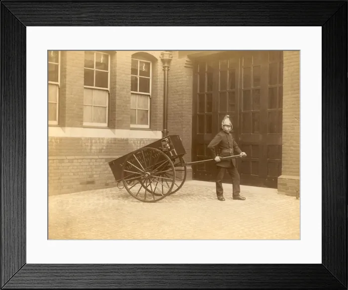 Framed Print : A firefighter of the London Fire Brigade pulling a cart Framed Print : A firefighter of the London Fire Brigade pulling a cart