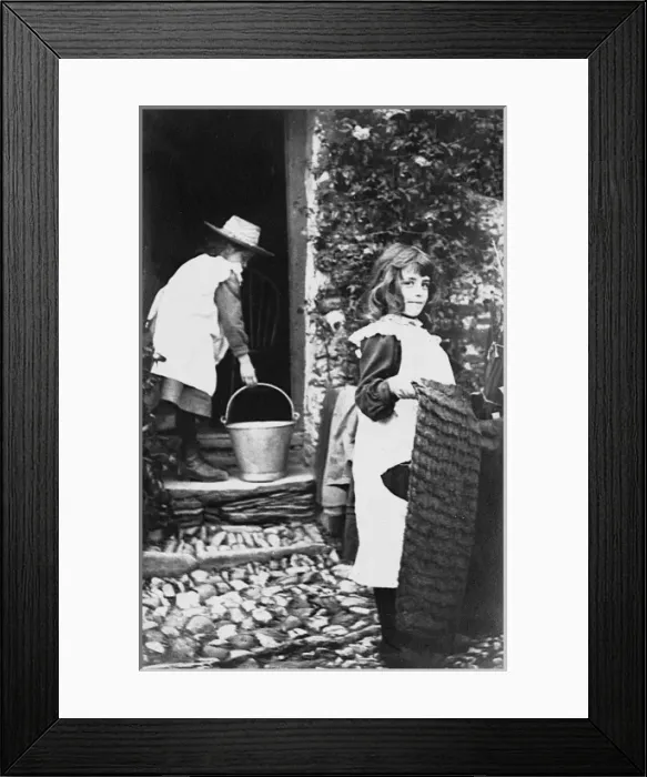 Framed Print : Two girls help their mother with the housework Framed Print : Two girls help their mother with the housework