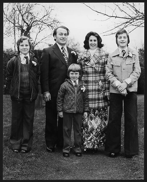 1970S FAMILY. A family with three young sons photographed wearing carnations at a wedding