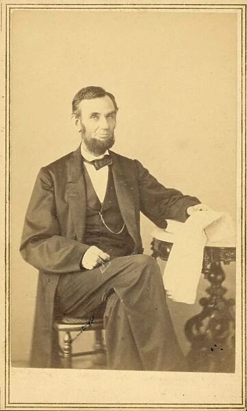 Abraham Lincoln, US President. Seated portrait, holding glas