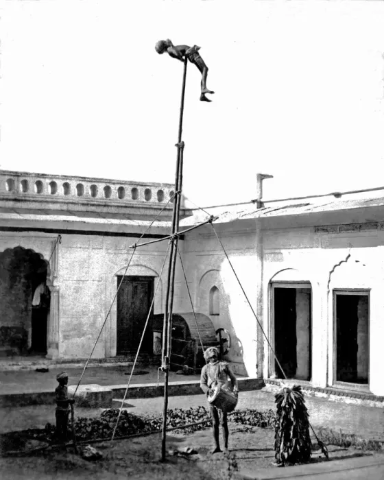 Framed Print : Acrobat on a pole, with drummer below, India Framed Print : Acrobat on a pole, with drummer below, India