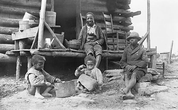 African-American children outside a log cabin in America