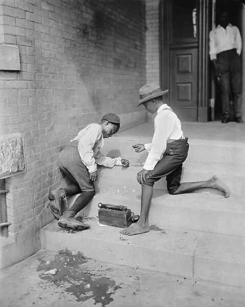 Two African American shoe shine boys playing a gambling game