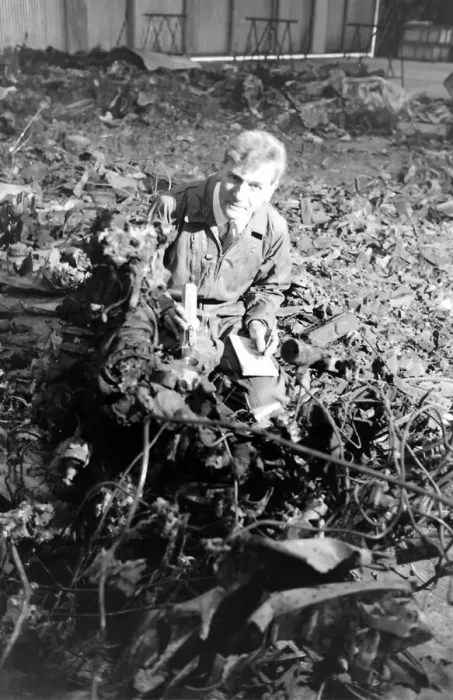 Framed Print : An air crash investigator at work in an indoor location with pieces of wreckage from a Framed Print : An air crash investigator at work in an indoor location with pieces of wreckage from a