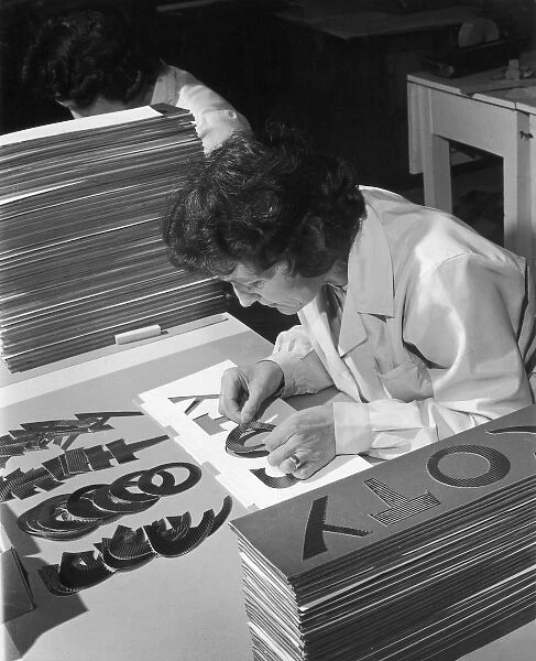 Assembling a Sign. A female factory worker assembles a sign as part of