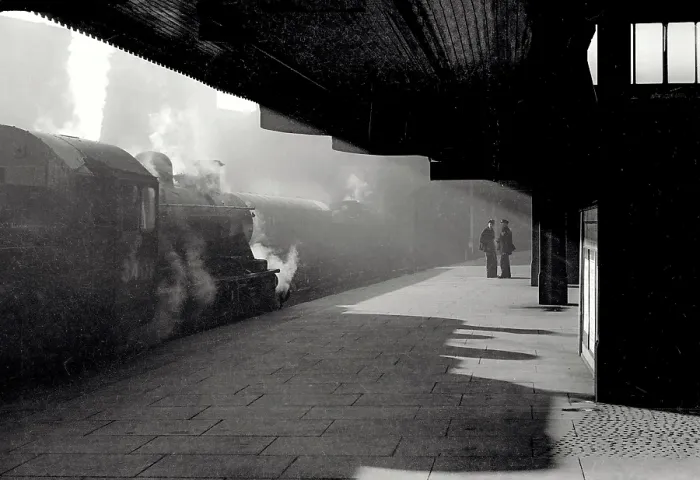 Framed Print : Atmospheric shot in station with strong diagonal light and silhouettes of train workers and train Date: early 1950s Framed Print : Atmospheric shot in station with strong diagonal light and silhouettes of train workers and train Date: early 1950s