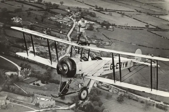 Framed Print : Avro 504K. Wing-Walking on an Avro 504K Flying over Fields Date: 1920s Framed Print : Avro 504K. Wing-Walking on an Avro 504K Flying over Fields Date: 1920s
