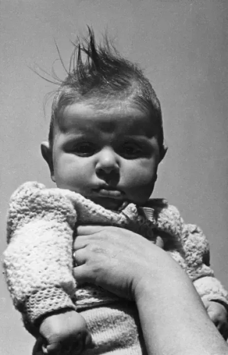 Framed Print : Baby in knitted jacket held up Framed Print : Baby in knitted jacket held up