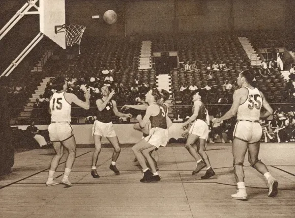 In this sparsely-attended basketball match at Harringay Arena, the American team (in white) beat the Swiss team. Date: 1948