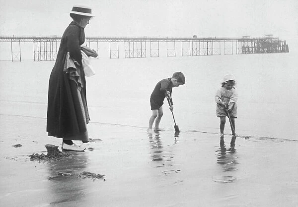 Beach Scene 1912. A little boy and girl play with their spades on the beach