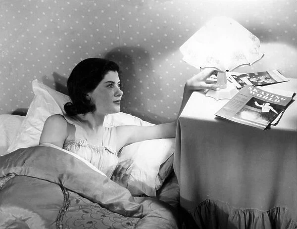 Bedside Lamp. A young woman, having enjoyed a bit of bedtime reading 