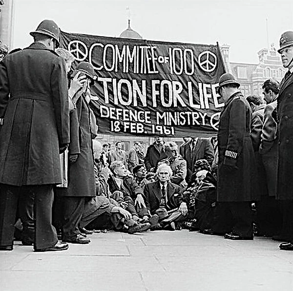 Bertrand Russell, British philosopher and author (1872-1970), sitting on the pavement with other protesters as part of a CND demonstration in London, under a large banner: Committee of 100, Action for Life, Defence Ministry, 18 February 1961