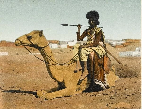 Bisharin Man holding a spear, whilst riding his camel