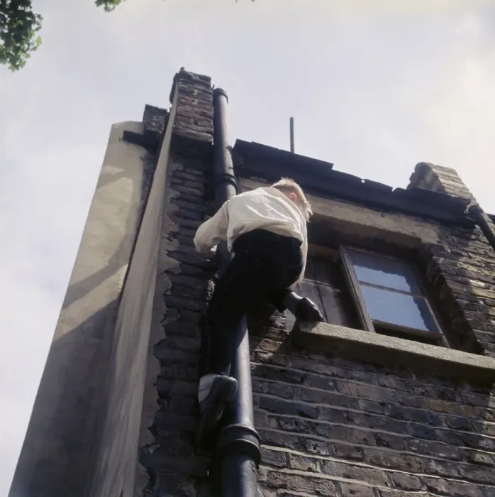 Framed Print : Boy climbing drainpipe on a Balham house, SW London Framed Print : Boy climbing drainpipe on a Balham house, SW London