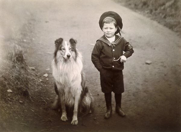 Boy and Collie. A rough collie sits beside a boy in a sailor suit