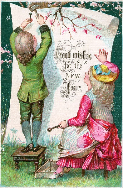 Boy and girl attaching New Year greeting to a tree