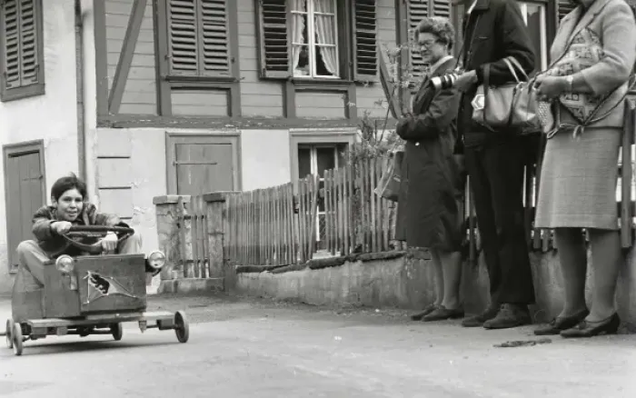 Framed Print : Boy on a go-kart passing three adults Framed Print : Boy on a go-kart passing three adults