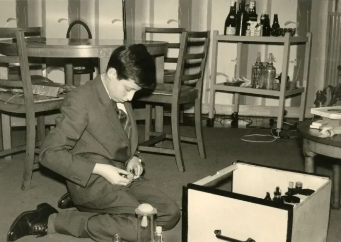 Framed Print : Boy kneeling on the floor sorting out some glass jars Framed Print : Boy kneeling on the floor sorting out some glass jars