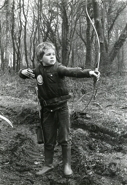 Boy practising archery in a wood