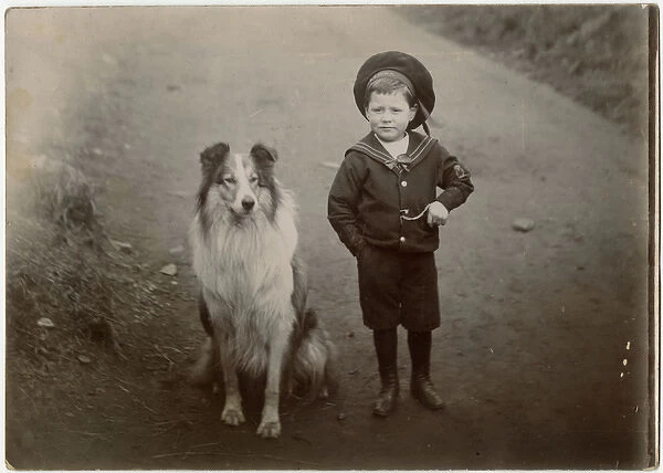 Boy in a sailor suit with a collie dog