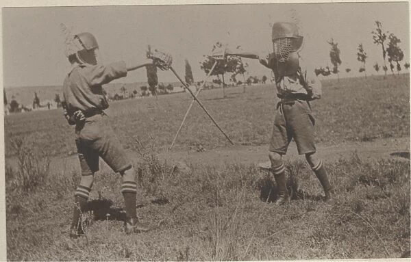 Two boy scouts fencing at camp