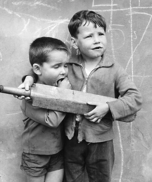 Two boys with cricket bat on a Balham street, SW London