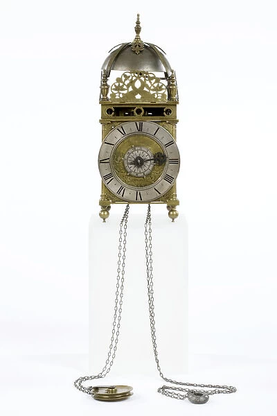 Clock. Brass and metal lantern clock on four ball feet