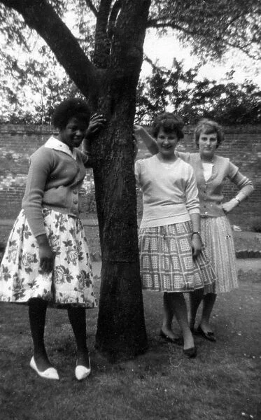 British Caribbean girl and two English girls standing by a t