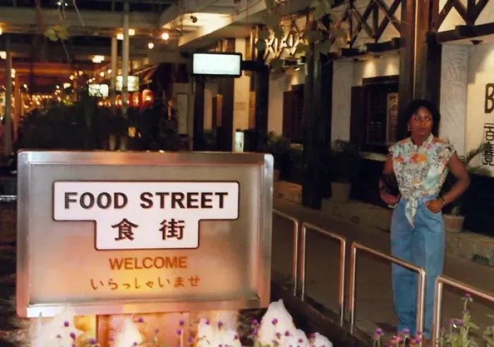 Framed Print : British Caribbean woman stands by Food Street sign, Hong K Framed Print : British Caribbean woman stands by Food Street sign, Hong K