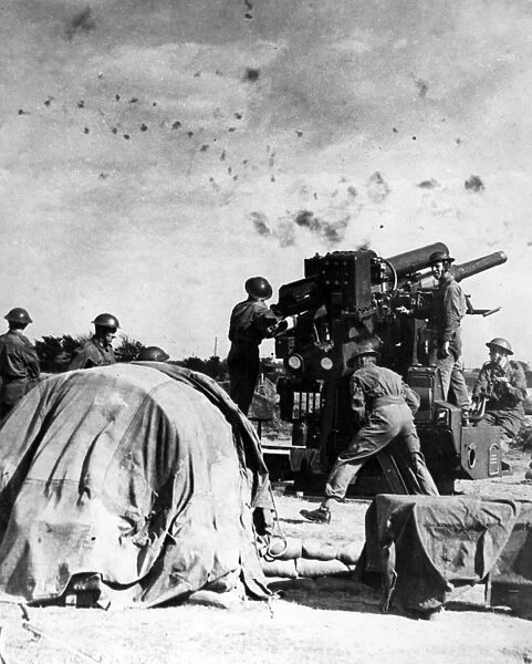 British gunners at work beneath a flak-filled sky, WW2