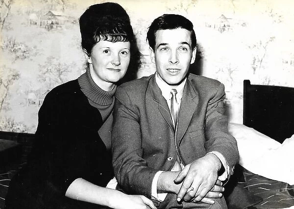 British lady with dark hair with fringe and man holding a ci