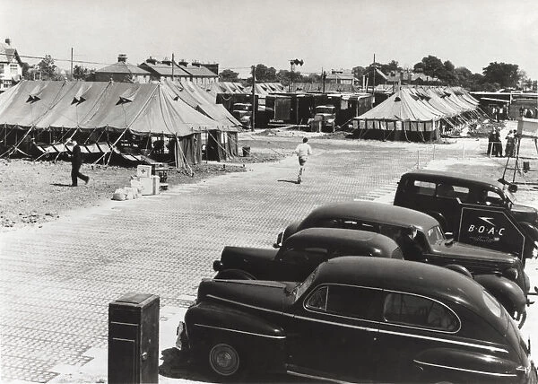 Cars Parked and Tents Used As Terminal Buildings with a ?