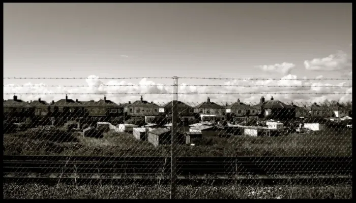 Framed Print : Chain link fence and houses by railway Framed Print : Chain link fence and houses by railway