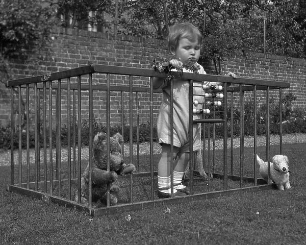Child in a playpen in a garden