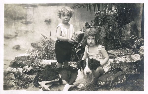 Two children with a dog in a garden, France