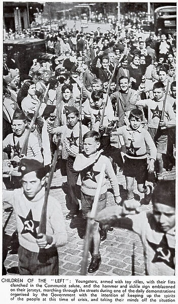 Children, dressed in Communist jumpers and with toy rifles, marching through the streets of Madrid during the Spanish Civil War, 1936. The children are shown giving the Socialist clenched-fist salute. Date: 1936