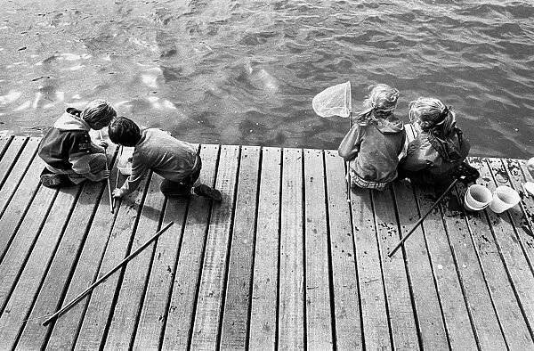 Children fishing for crabs on wooden pontoon, New Brighton