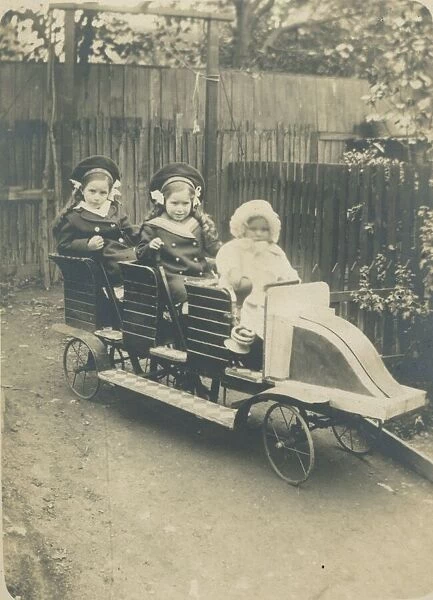 Three children in a very impressive toy car. We can only hope the baby at the front isn t