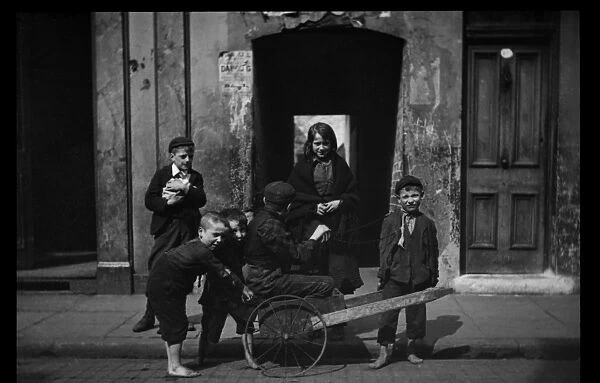Six children with a makeshift cart in a London street