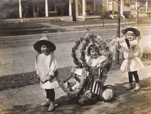 Three children with patriotic pushchair, USA