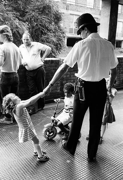 Children play with policeman in a block of flats in Brixton