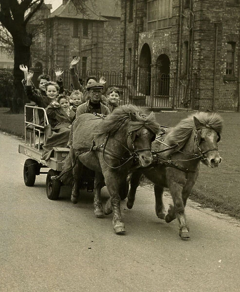 Children riding in cart pulled by ponies, Manchester