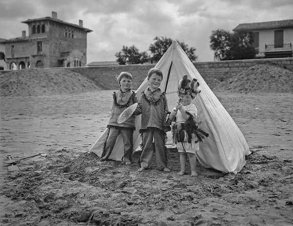 Three children with tent on a beach