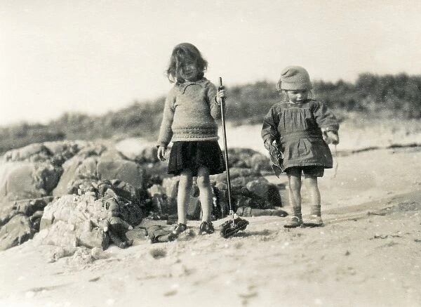 Two children with toys on a beach, Scotland