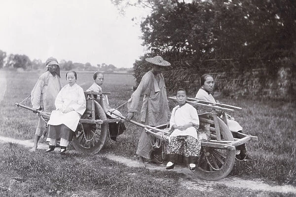 Chinese women being transported by wheelbarrow