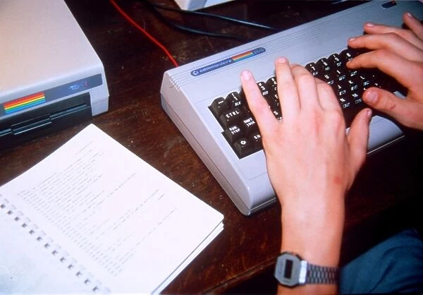 Commodore 64. A person wearing a digital watch types at a Commodore keyboard