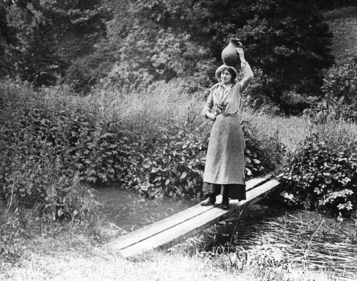 Framed Print : Countrywoman carrying a pot over a bridge, 1890s